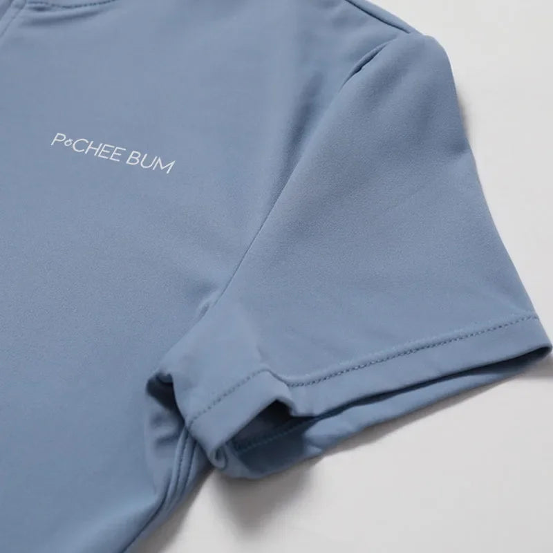 Light blue short-sleeve romper close-up of chest logo and stitched hem