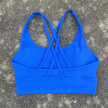 Women's padded cross-back sports bra in bright blue with crisscross back straps