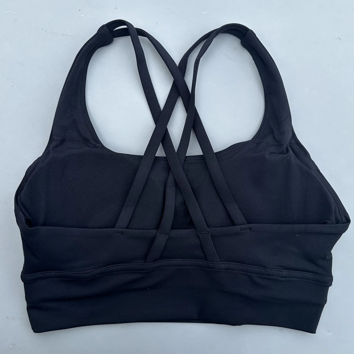 Women's cross-back padded sports bra in dark navy with crisscross back straps and band.