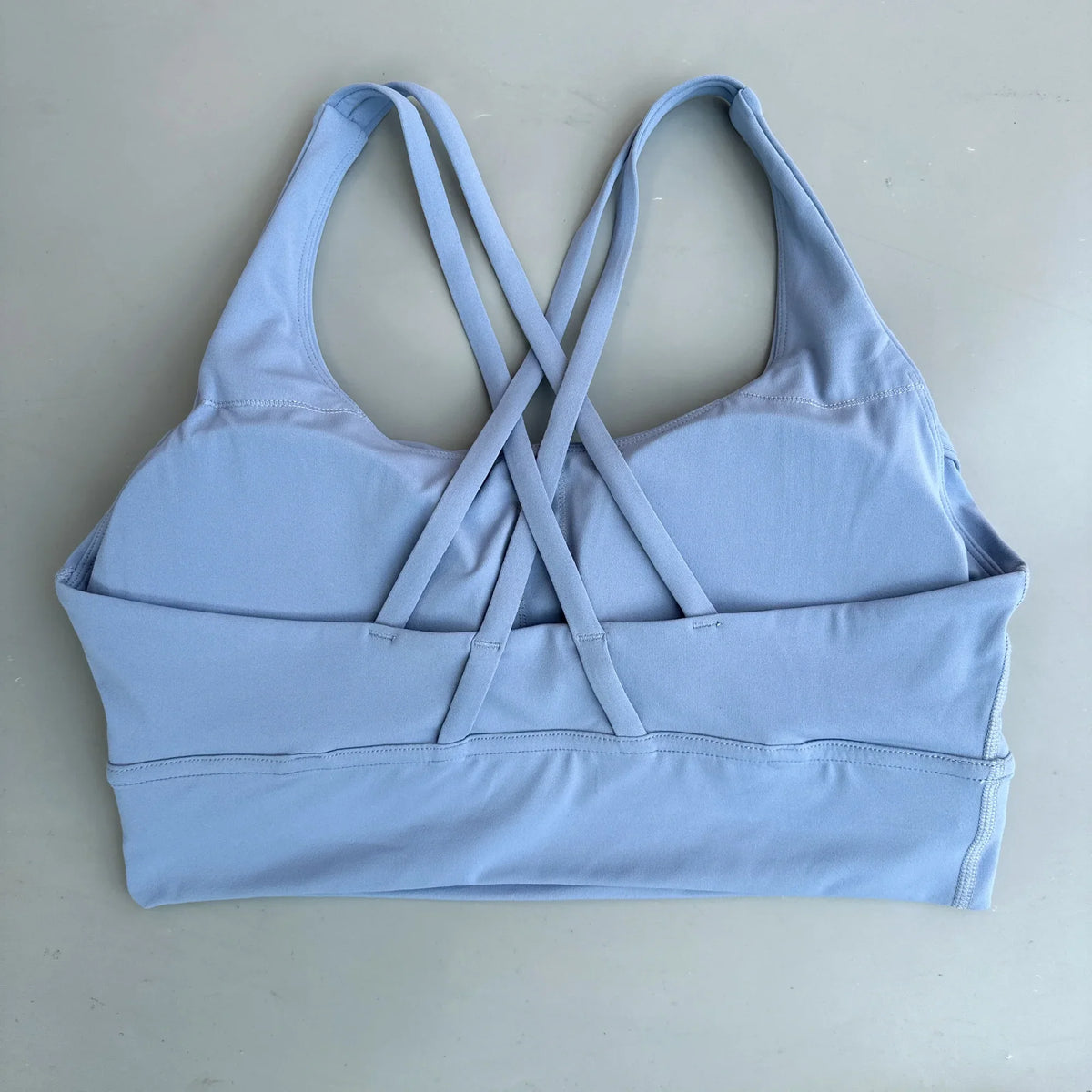 Powder blue padded sports bra with crisscross cross-back straps and wide underband.
