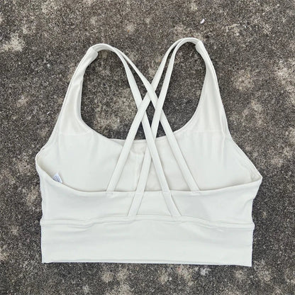 Women's padded cross-back sports bra in white with crisscross back straps