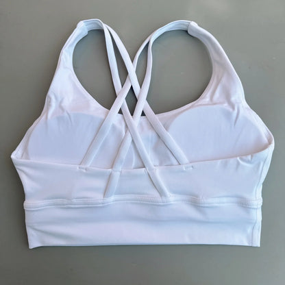Women's cross-back padded sports bra in white with crisscross back straps and wide band.