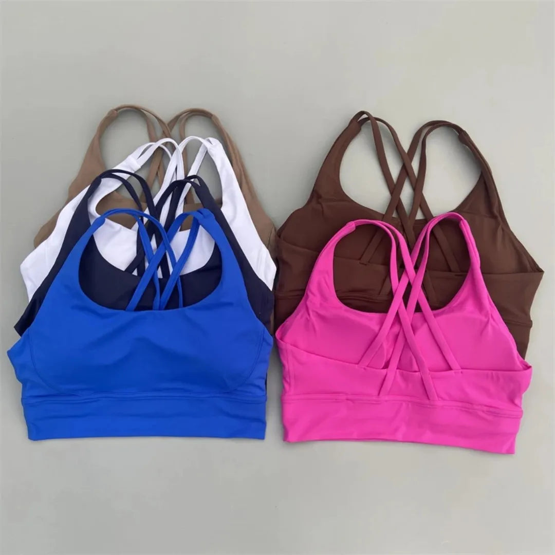 Women's cross-back padded sports bras in blue and fuchsia pink with crisscross straps.