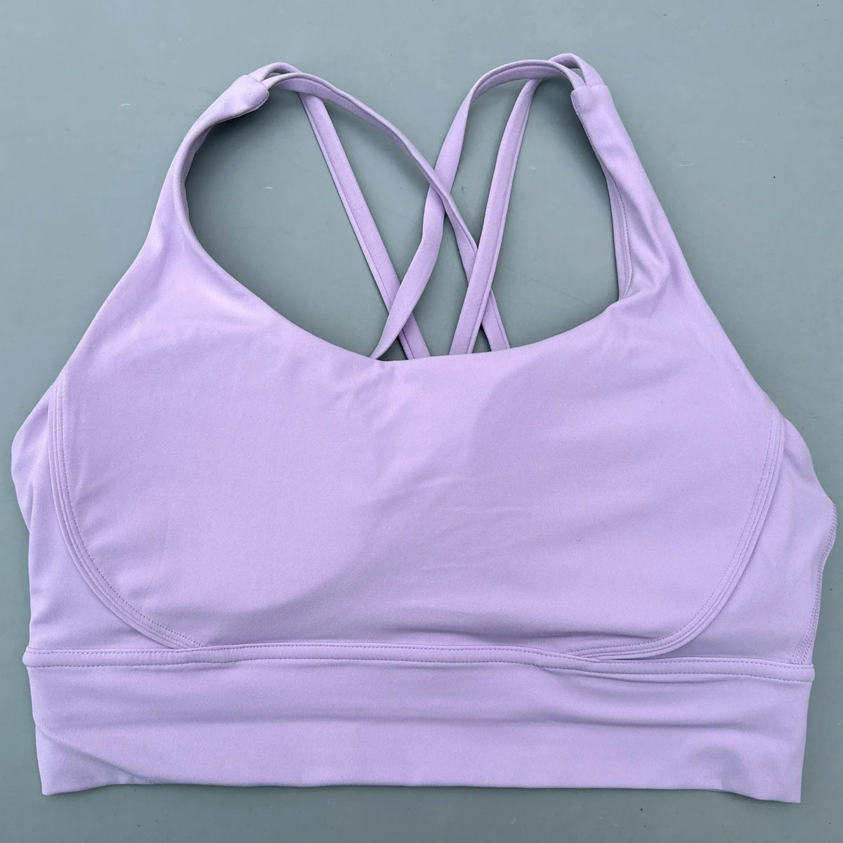 Light purple padded sports bra with crisscross cross-back straps and wide band.