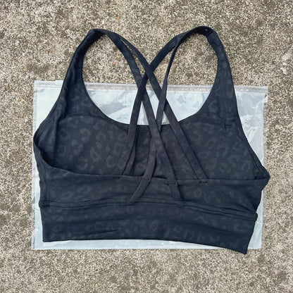 Dark navy padded sports bra with crisscross cross-back straps and wide underband.