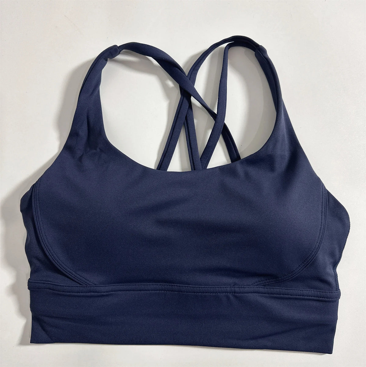 Deep navy cross-back padded sports bra with wide band and racer back straps
