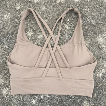 Light beige padded cross-back sports bra with wide band and crisscross straps