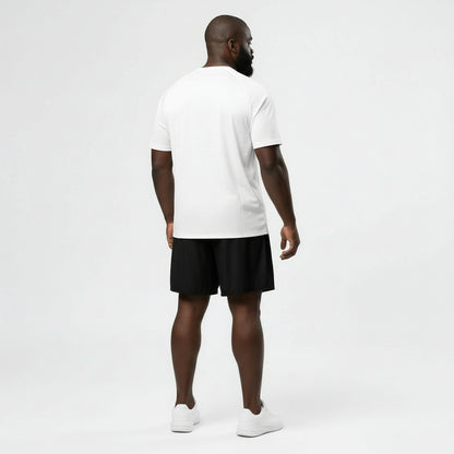 Man wearing a white t-shirt with '1983' print and black shorts on a white background