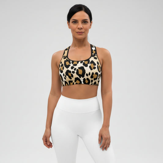 Woman wearing a leopard print sports bra and white leggings on a gray background
