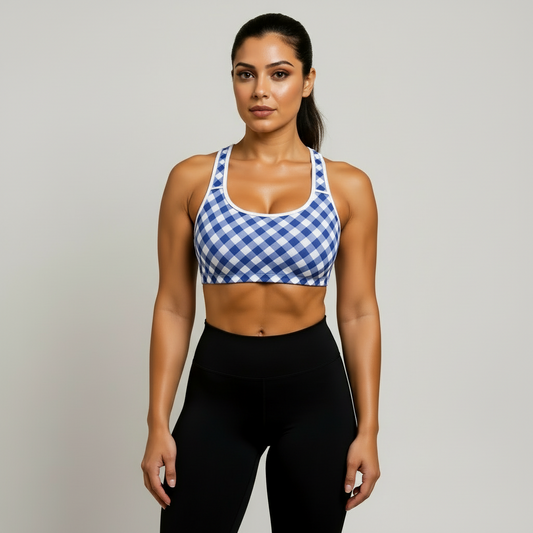 Woman wearing a blue and white checkered sports bra and black leggings on a beige background