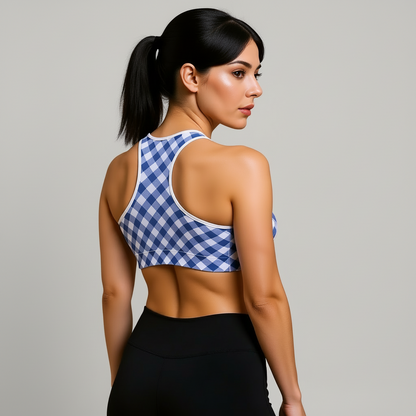 Woman wearing a blue and white checkered sports bra and black leggings on a beige background