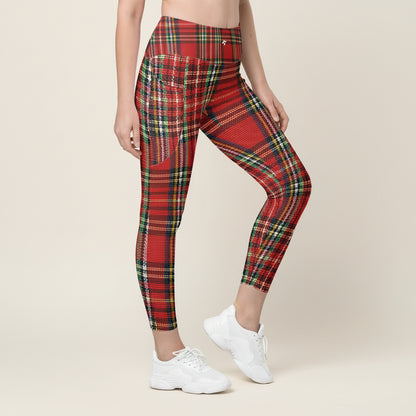 A person wearing red tartan patterned leggings with pockets, paired with white sneakers.