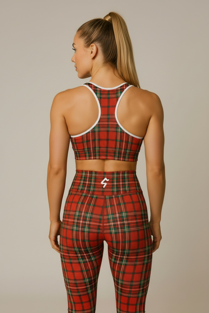 Person wearing a red plaid sports bra and leggings set on a beige background