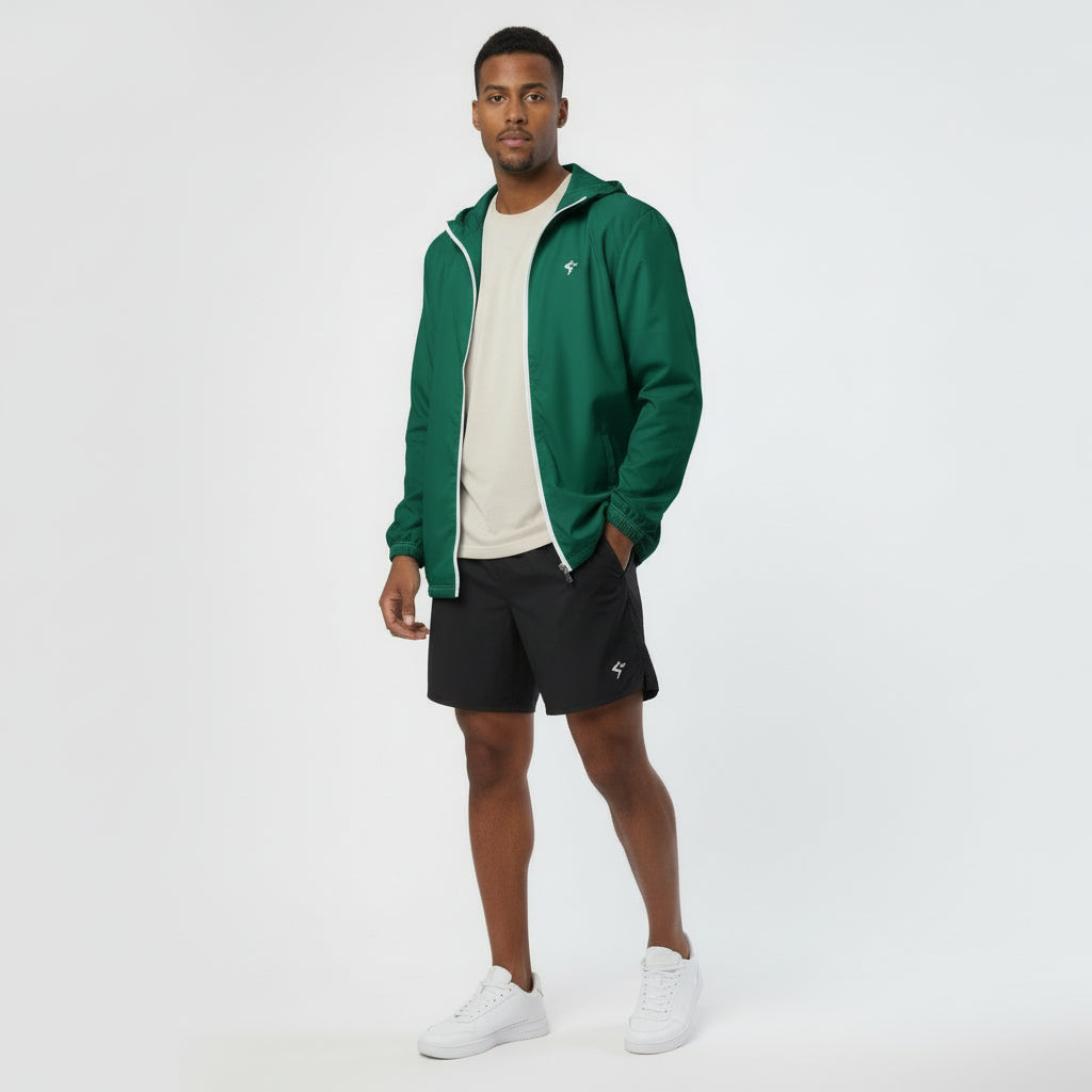 Man wearing a green jacket, white shirt, black shorts, and white sneakers on a white background