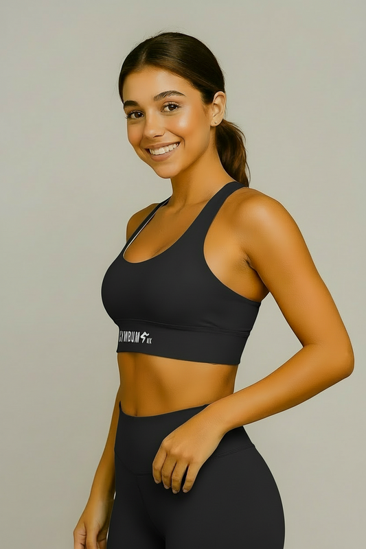 Woman wearing a black sports bra with a brand logo on a beige background