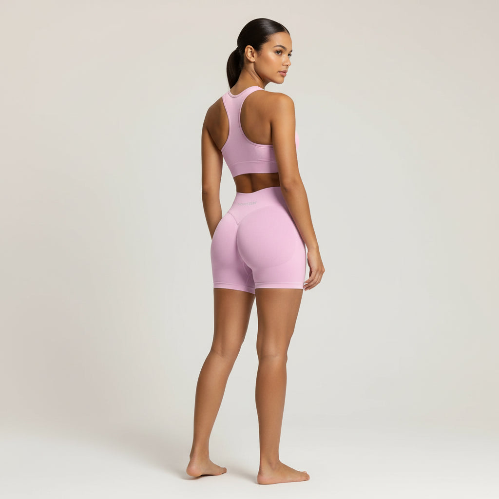 Woman wearing a pink athletic outfit on a plain background