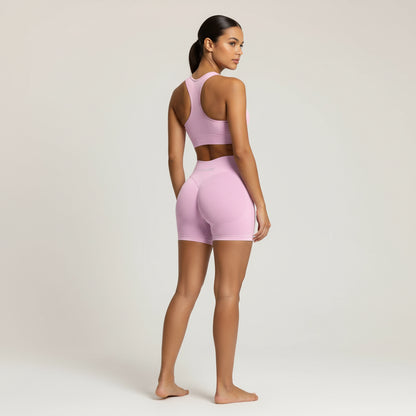 Woman wearing a pink athletic outfit on a plain background