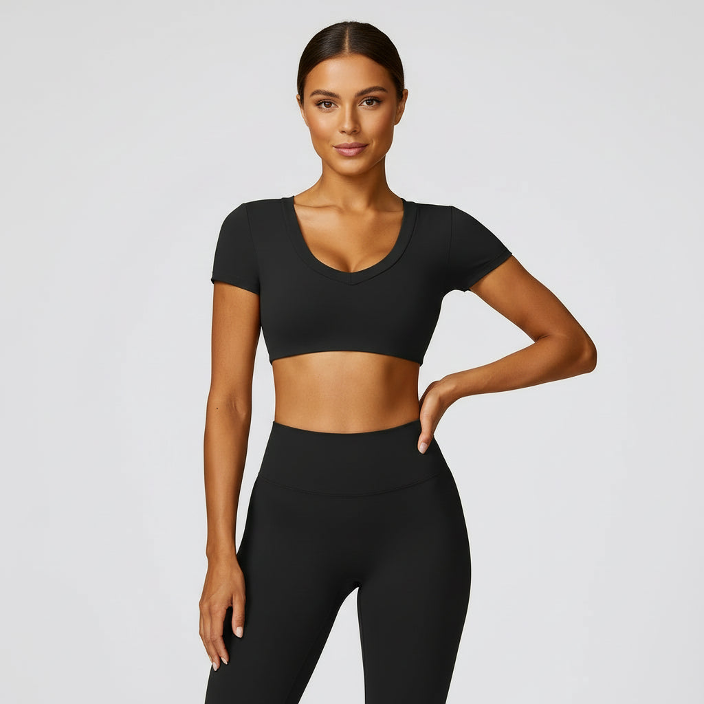 Woman wearing a black athletic outfit on a light gray background