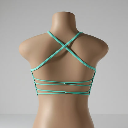 A woman wearing a white seamless sports bra and green Activewear leggings.