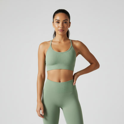 A woman wearing a white seamless sports bra and green Activewear leggings.
