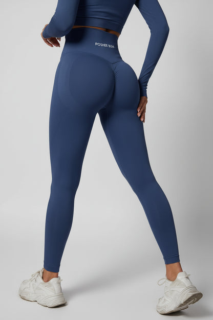 Person wearing blue leggings with a visible brand logo on a light gray background