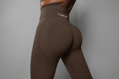 Brown leggings with 'Pochee Bum' logo on a dark background