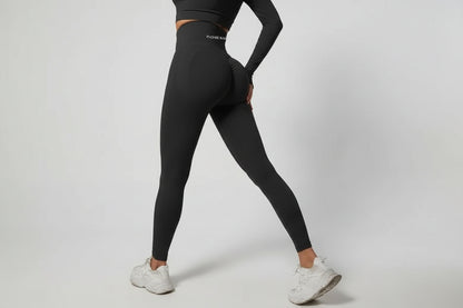 Person wearing black leggings with a visible brand logo against a gray background
