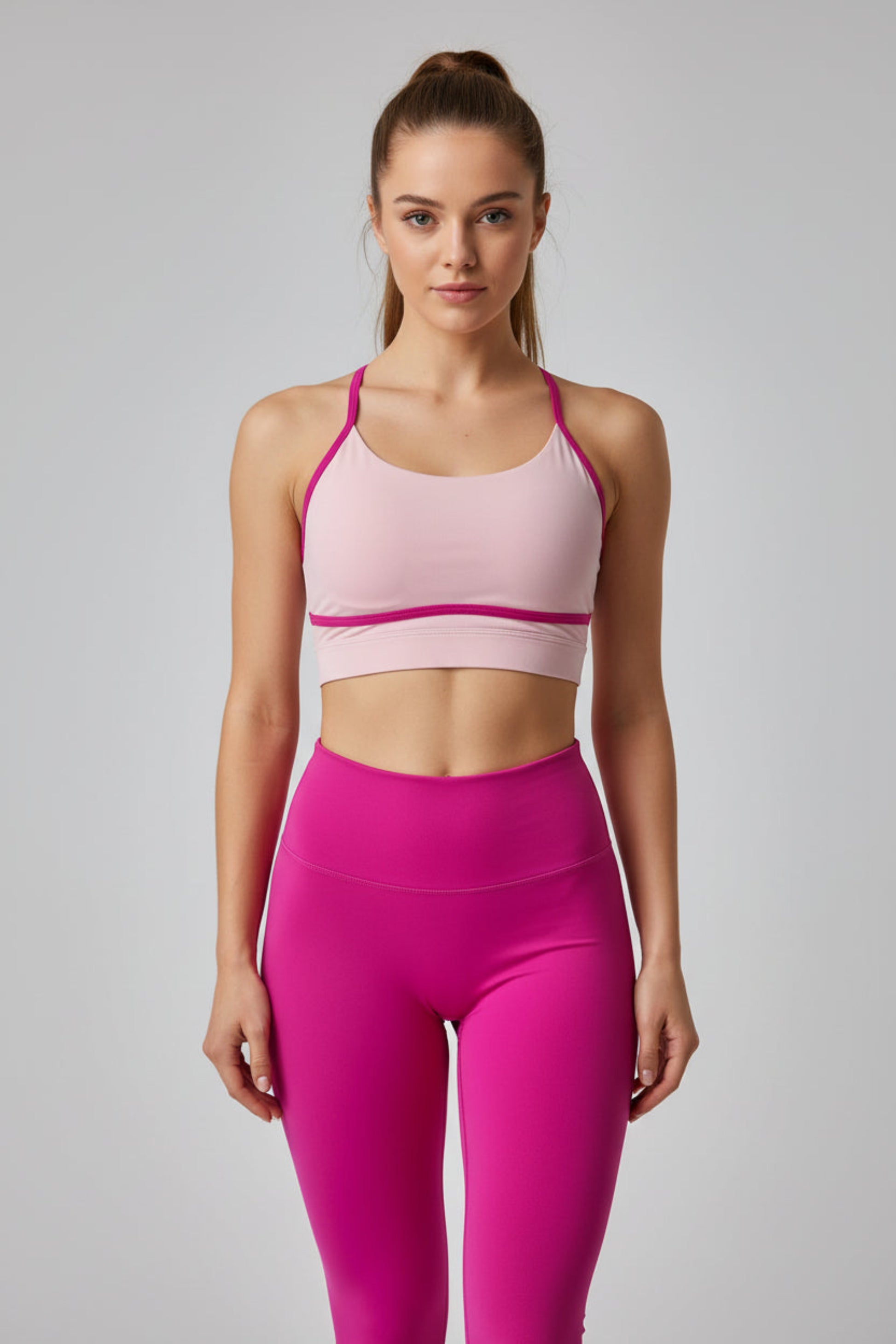 Pink sports bra and leggings set on a light gray background