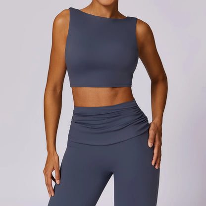 A gray tank top with wide shoulder straps and a low back, made of nylon fabric, on a model.