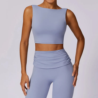 A gray tank top with wide shoulder straps and a low back, made of nylon fabric, on a model.