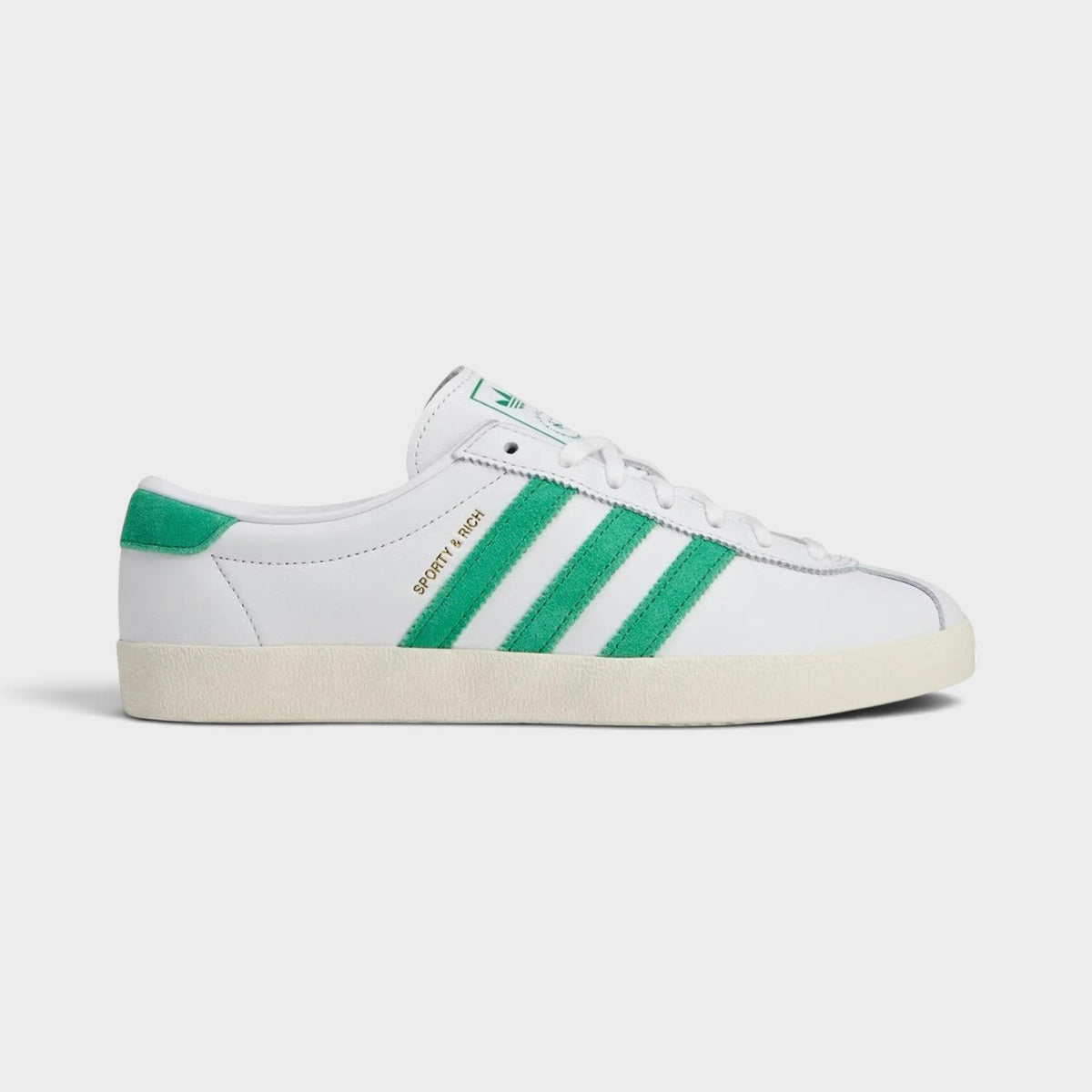 Adidas white leather sneakers with green three-stripe sides and lace-up design