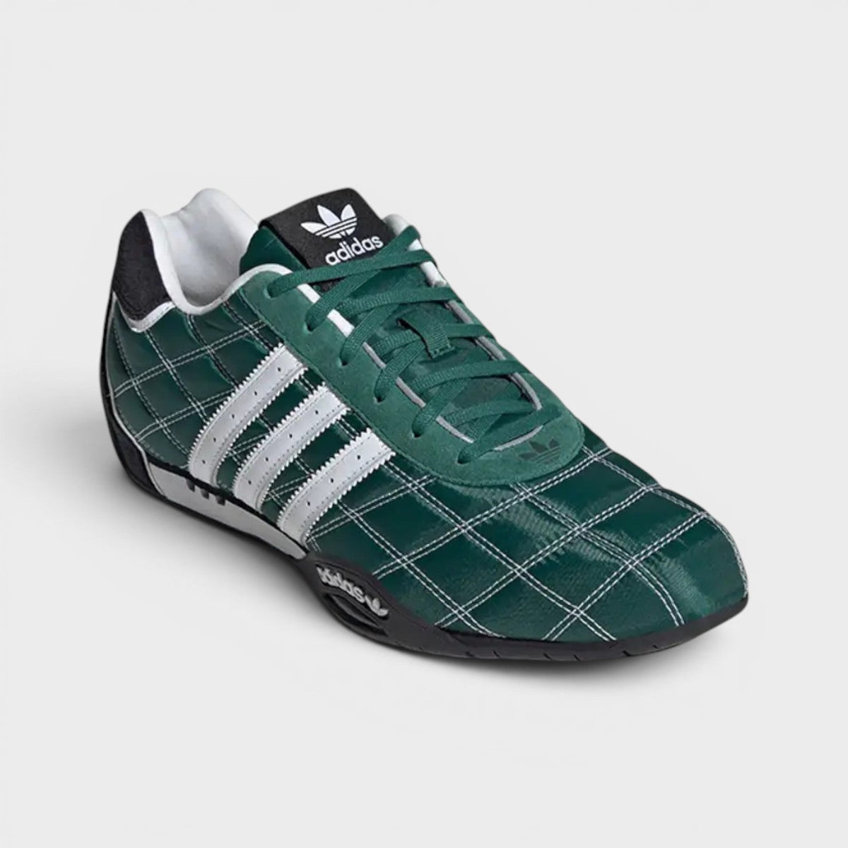 Green low-top Adidas sneakers, side view with white triple stripes and black sole