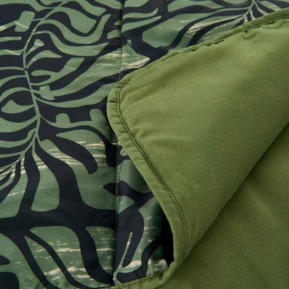 Close-up of dark teal and green leaf-pattern camping blanket with stitched edge