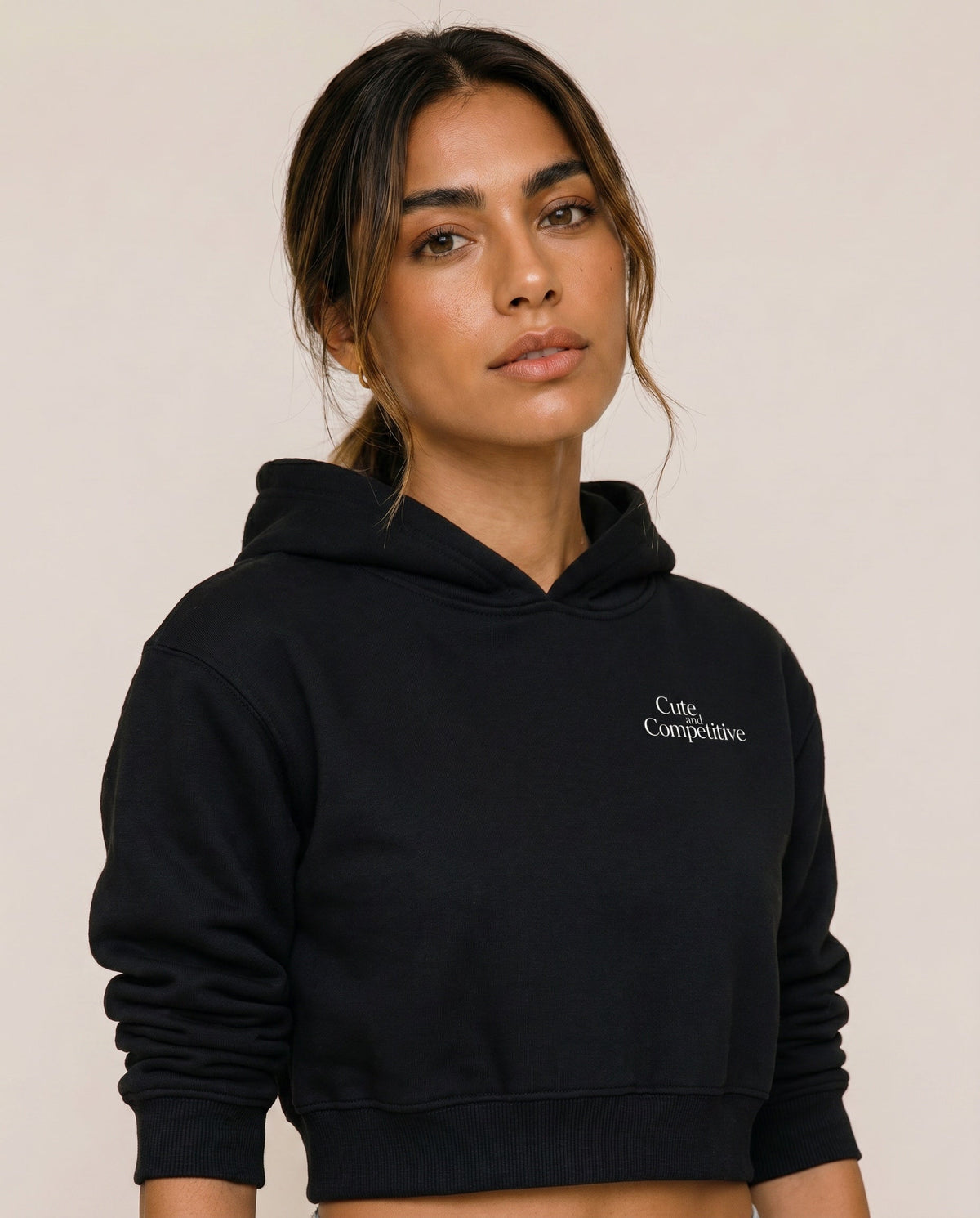Black cropped hoodie with hood and small chest logo, shown from the front.