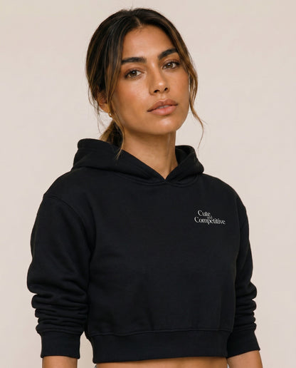 Black cropped hoodie with hood and small chest logo, shown from the front.