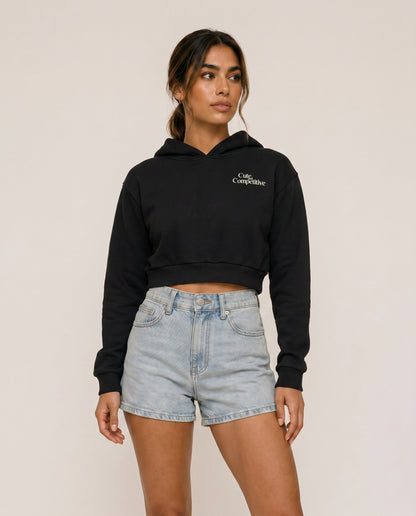 Black cropped hoodie with hood and small chest logo, front view.