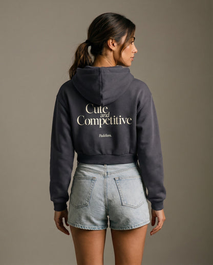 Charcoal gray cropped hoodie with hood and large back logo text.