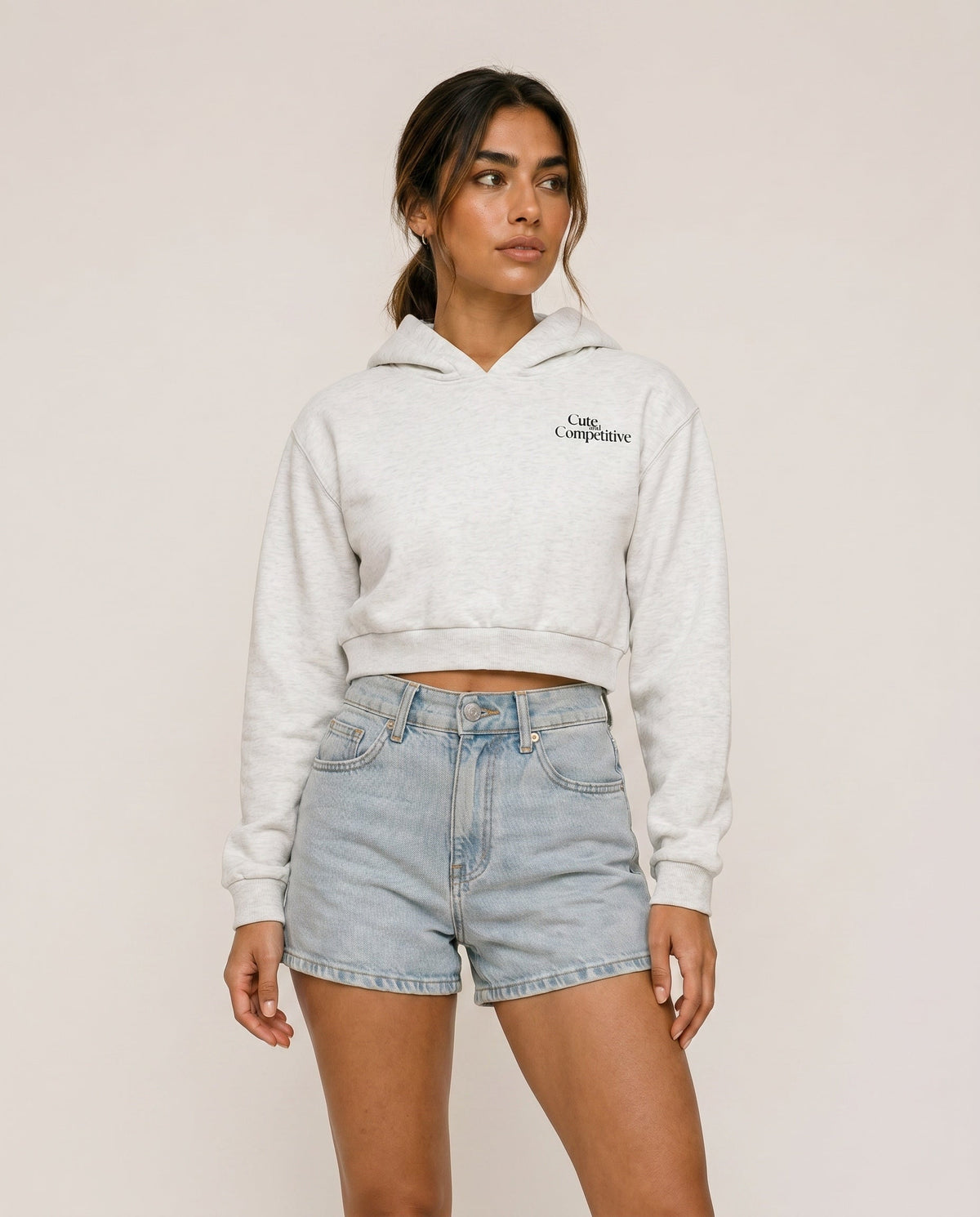 Light gray cropped hoodie with hood, front logo, and kangaroo pocket