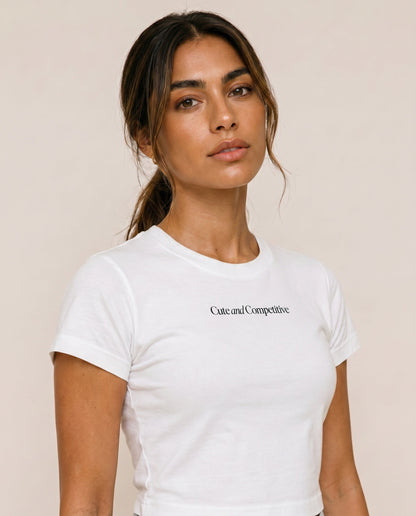 Cropped white crew-neck T-shirt with short sleeves; “Cute and Competitive” chest print