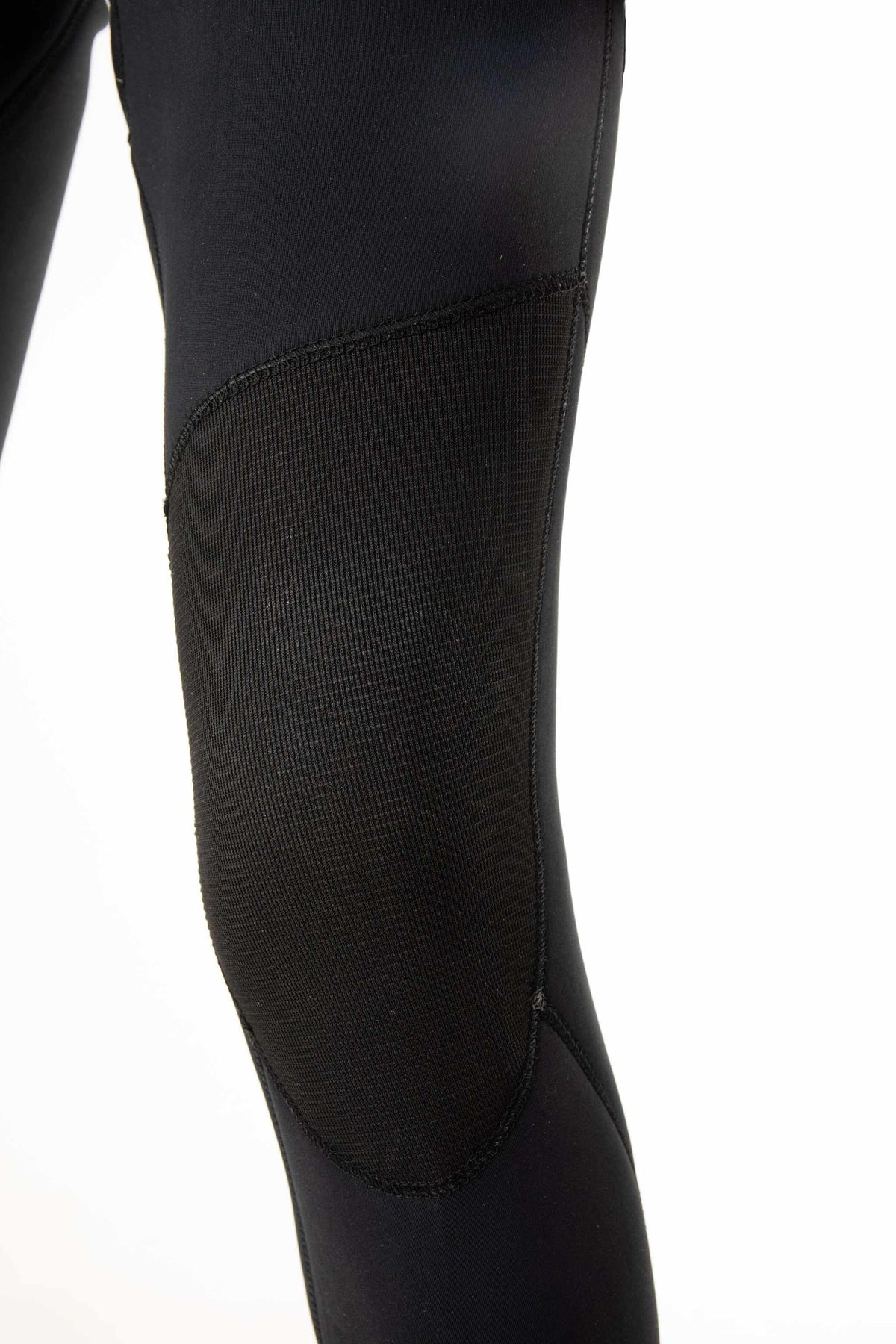 Close-up of black wetsuit leg panel with textured fabric and seam details