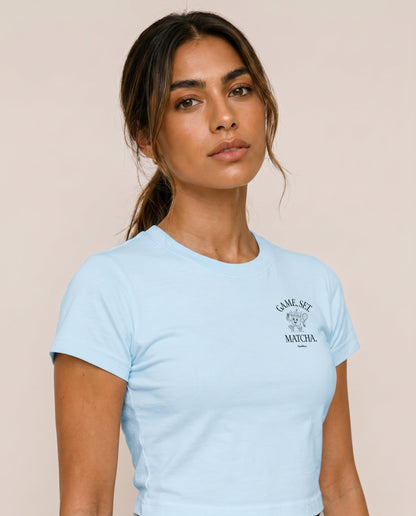 Light blue crewneck t-shirt close-up with "Game, Set, Matcha" logo on left chest.
