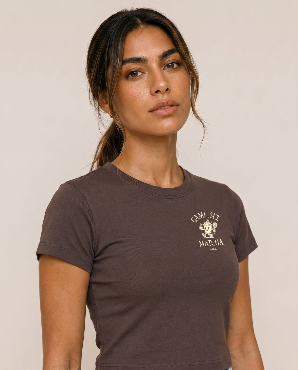 Brown crewneck t-shirt close-up with "Game, Set, Matcha" logo on left chest.