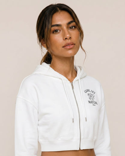 White cropped zip hoodie with hood, drawstring, and small chest logo print