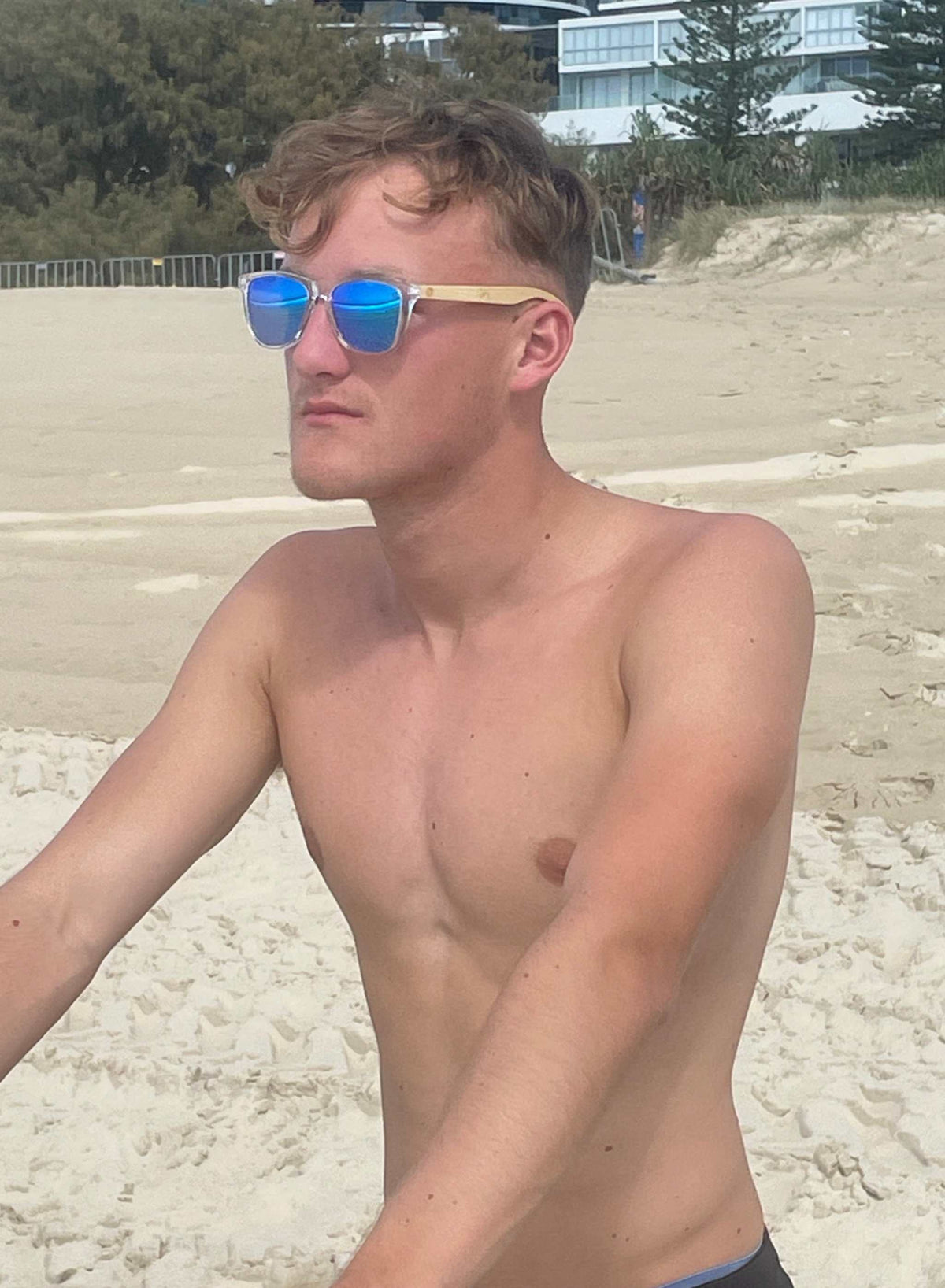 Eco friendly sunglasses on a person, clear frame with blue tinted lenses