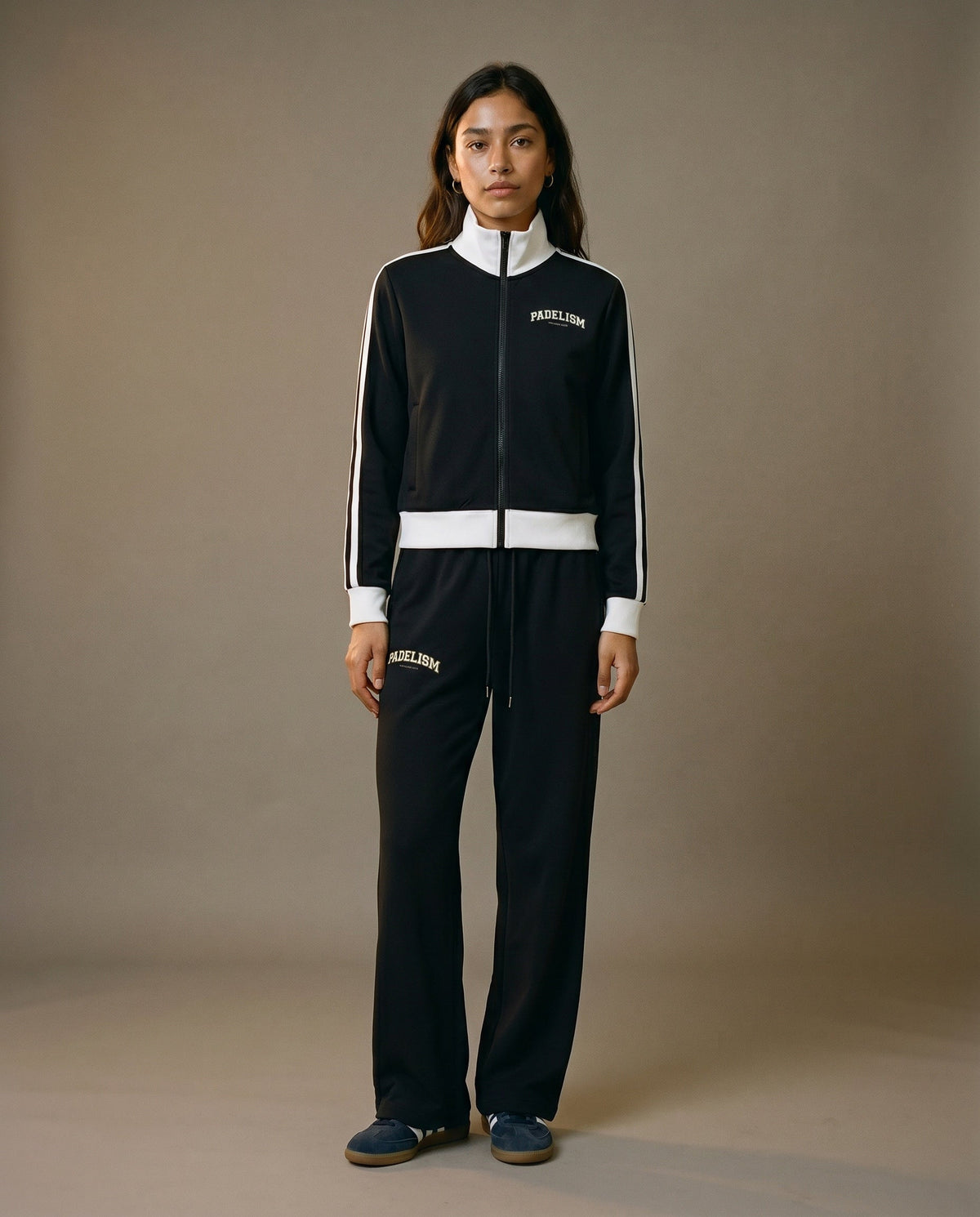 Black track jacket with white zipper, striped sleeves, and small chest logo