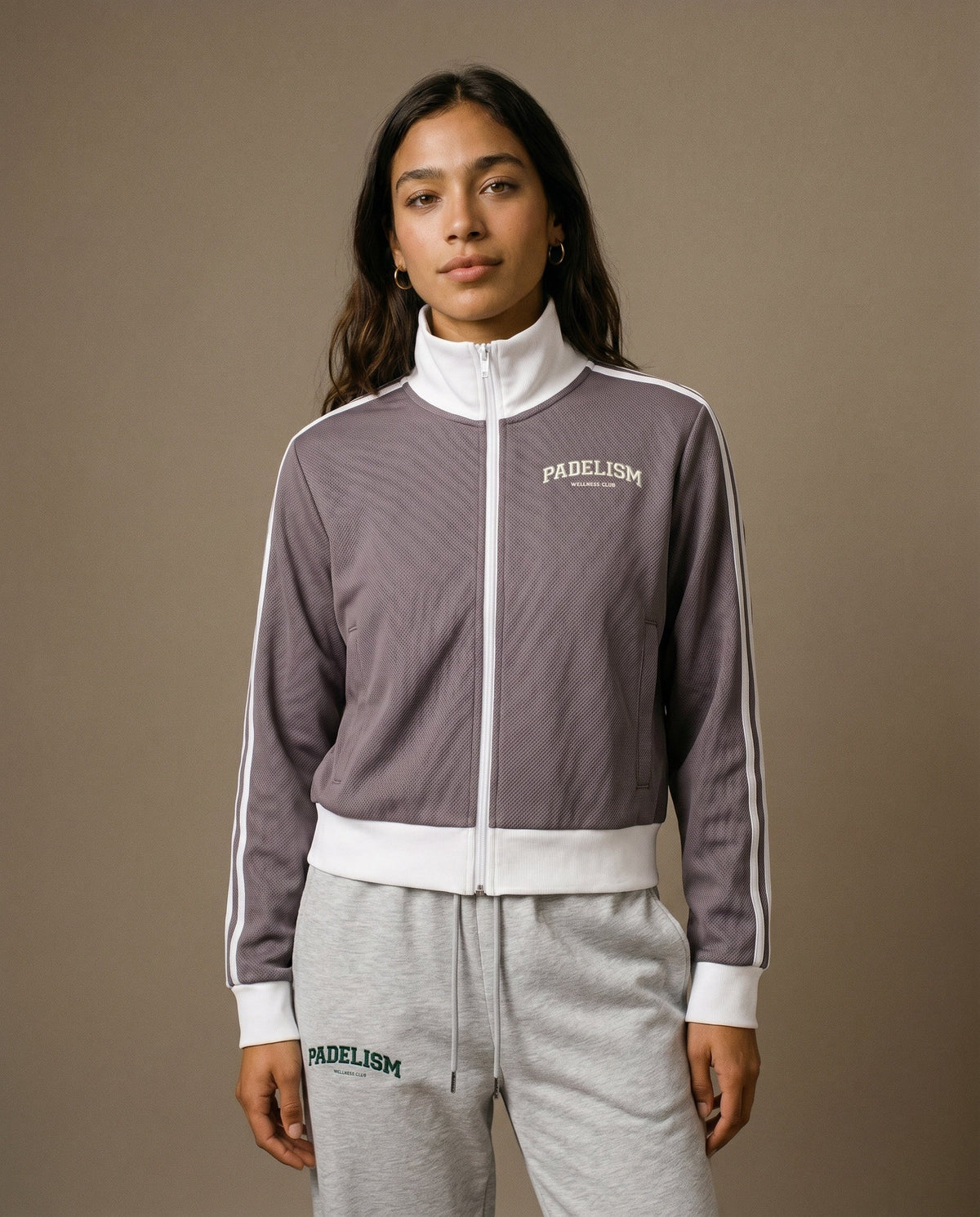 Plum purple track jacket with white zipper, striped sleeve panels, chest logo