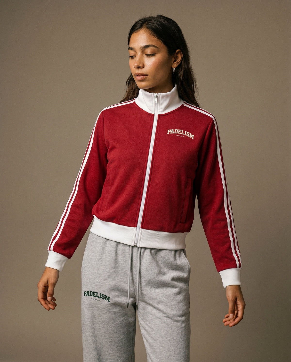 Red track jacket with white zipper, striped sleeves, and small chest logo