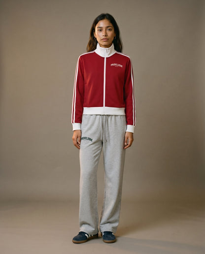 Red track jacket with white zipper, stand collar, and white side stripe detailing