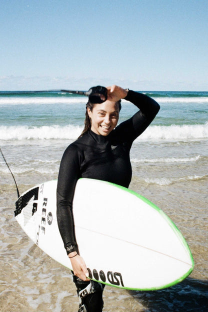 Women’s 4/3 chest zip steamer wetsuit in black, holding a surfboard