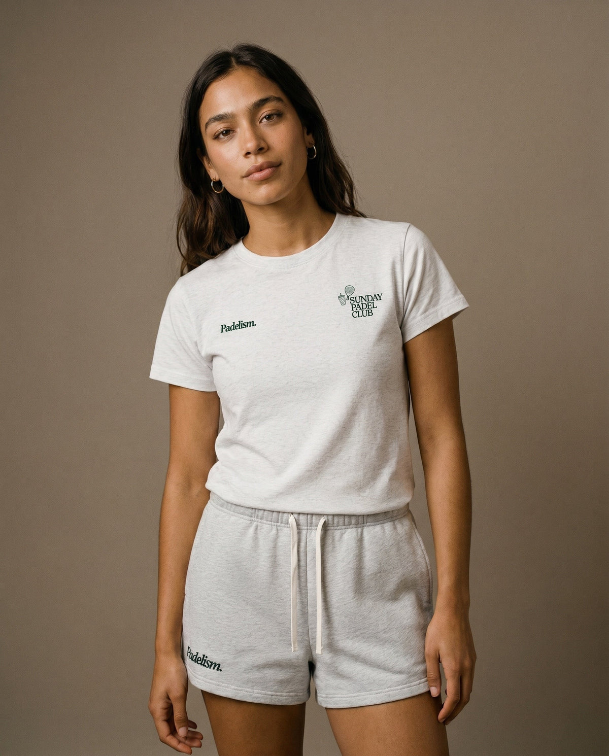White crewneck short-sleeve t-shirt with small chest prints, paired with light gray shorts